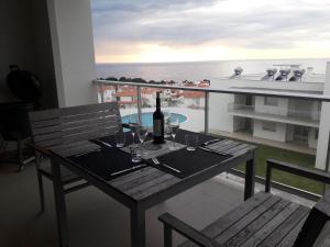 - une table avec une bouteille de vin sur le balcon dans l'établissement Erik Apartment, à Nazaré