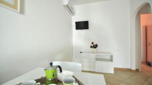 a white kitchen with a table and a counter top at Villetta Bianca by Salento Affitti in Torre San Giovanni Ugento
