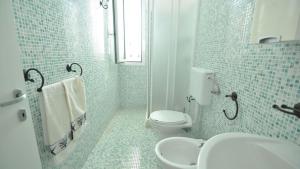 a white bathroom with a toilet and a sink at Villetta Bianca by Salento Affitti in Torre San Giovanni Ugento +17 photos
