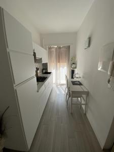 a kitchen with a table and a white refrigerator at Chez Telly 31 in Verona