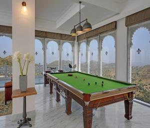 a pool table in a room with windows at Fateh Safari Suites by Fateh Collection in Kumbhalgarh