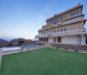 a large building with a lawn in front of it at Fateh Safari Suites by Fateh Collection in Kumbhalgarh