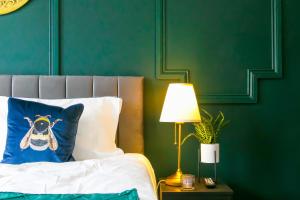 Una cama con una almohada azul y una lámpara sobre una mesa en The Mayfield Apartment Hotel, en Sunderland