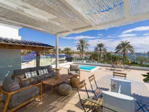 a patio with a couch and chairs and a pool at Pasitoblanco Porto Mare 45 Seaview Villa prívate heated pool in Pasito Blanco