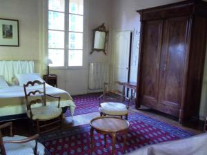 a bedroom with a bed and two chairs and a table at Chateau de La Motte Daudier in Craon