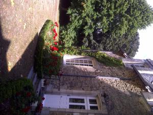 a building with a white door and some flowers at Chateau de La Motte Daudier in Craon