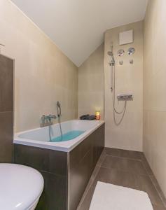 a bathroom with a bath tub and a toilet at Altstadtapartment, 80 qm,2 Schlafzimmer,Parkplatz,Netflix in Cottbus
