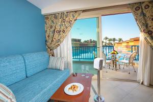 a living room with a blue couch and a balcony at Titanic Palace - Families and Couples only in Hurghada