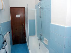 y baño con bañera y ducha con azulejos azules. en Casa Rachele, en Piano di Sorrento