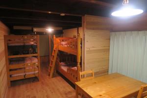 a room with two bunk beds and a table at Guesthouse ONE WORLD in Kitsuki