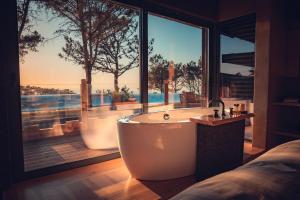 a bath tub in a room with a large window at Charm Nature in Azoia