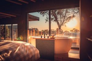 a bath tub in a bedroom with a large window at Charm Nature in Azoia