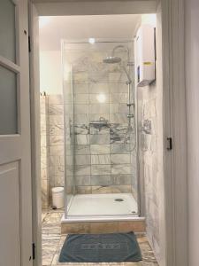 uma casa de banho com um chuveiro e uma porta de vidro em Living in History - Modern Country Cottage em Dudeldorf