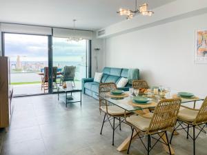 - un salon avec une table et un canapé bleu dans l'établissement Apartamento Seascape. Relax, lujo y vistas al mar., à Finestrat
