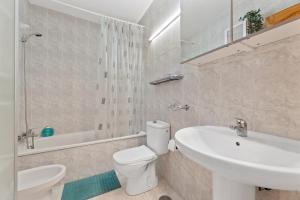 a white bathroom with a toilet and a sink at Casa Donna in Playa Honda +6 photos