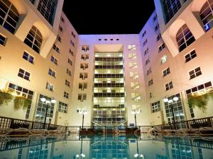 a large building with many windows and a pool of water at Novotel Firenze Nord Aeroporto in Sesto Fiorentino