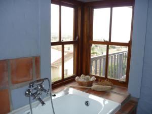 a bath tub in a bathroom with a window at The Gem sea facing free standing holiday house solar power in Jeffreys Bay