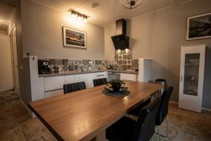 a dining room with a wooden table and chairs at Brinkzicht Diever, appartement Bert in Diever