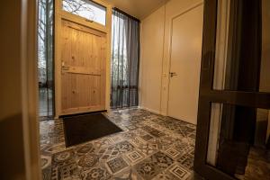 a hallway with a door and a tile floor at Brinkzicht Diever, appartement Maaike in Diever +35 photos