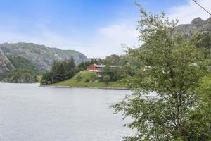 una casa su una collina vicino a un corpo d'acqua di Brufjell Hostel & Parking a Flekkefjord