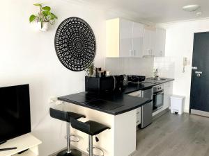 uma cozinha com um balcão preto num quarto em Heart of Manly Apartment em Sidney