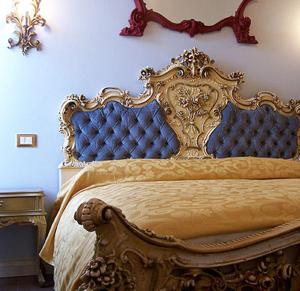 1 cama con cabecero azul y dorado en un dormitorio en Atmosfera, en Rávena
