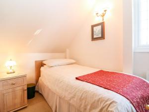 a bedroom with a bed with a red blanket on it at Chestnut Apartment in Cheltenham