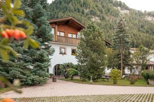 a house in the middle of a park with trees at Villa Moroder in Ortisei