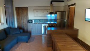 a living room with a blue couch and a kitchen at Casa Rural del GUARDAGUJAS in Villanueva del Duque