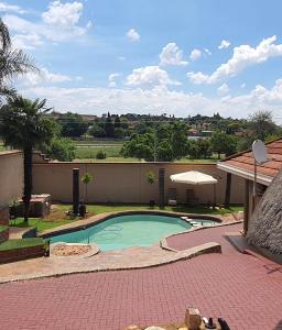 een klein zwembad in een tuin met een gebouw bij Langa's Gabedi Goshen in Pretoria