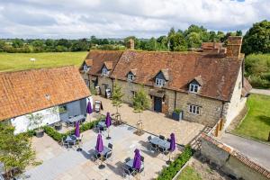 une vue aérienne sur un bâtiment avec des tables et des parasols violets dans l'établissement The Dinton Hermit, à Dinton