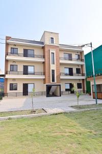 a large apartment building with a lawn in front of it at Ideal Home stay in Amritsar