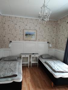 Habitación con 2 camas y lámpara de araña. en STF Hostel Visby/Rävhagen en Visby
