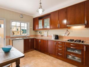 a kitchen with wooden cabinets and a counter top at Holiday Home Sunny Home by Interhome in Pêra