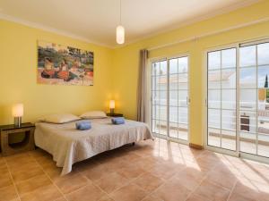 Un dormitorio con una cama y una ventana grande. en Holiday Home Sunny Home by Interhome, en Pêra 10 fotos más