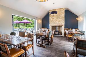 a restaurant with tables and chairs and a fireplace at The Dinton Hermit in Dinton