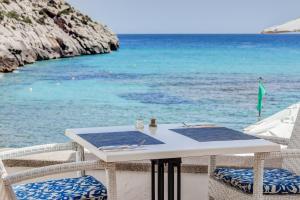 
a white and blue table with chairs and a blue water fountain at Hoposa Niu in Cala de Sant Vicenc
