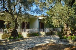 a house with trees and flowers in front of it at Guesthouse Irene in Afissos