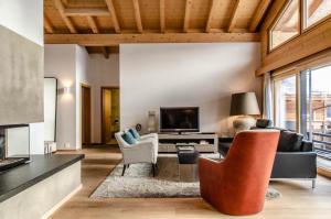 a living room with a couch and chairs and a television at Apartment Silbersee - GRIWA RENT AG in Grindelwald
