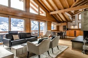 a living room with a couch and chairs at Apartment Silbersee - GRIWA RENT AG in Grindelwald