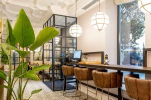 a bar in an office with a plant and pendant lights at L&H Gran Vía Valencia in Valencia