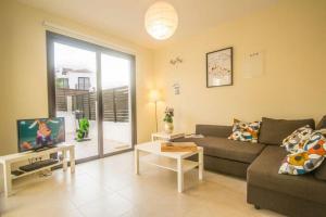 een woonkamer met een bank en een tafel bij Protaras Allium Villa in Protaras
