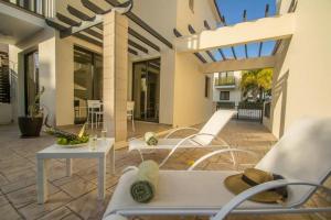 een patio met witte stoelen en een tafel bij Protaras Allium Villa in Protaras