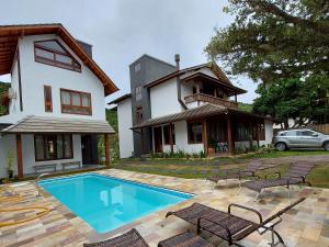 una casa con piscina frente a una casa en Refúgio 755, en Florianópolis