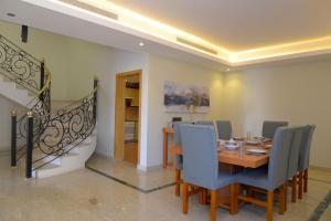 a dining room with a table and chairs and a staircase at بيوت عطلات التلال الفاخرة للايؤاء السياحي altelal alfakhra holiday homes in Taif