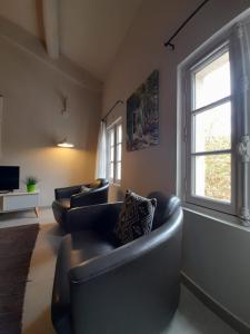 a living room with two couches and a window at Apparts Et Lofts Bistrot Des Alpilles in Saint-Rémy-de-Provence