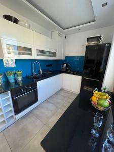 a kitchen with white cabinets and a black counter top at LUXURY BLUE APARTMENT by Marta in Radom