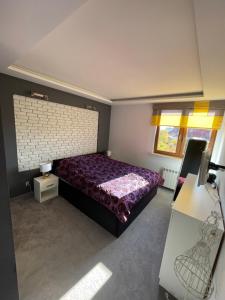 a bedroom with a purple bed and a window at LUXURY BLUE APARTMENT by Marta in Radom
