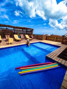 a swimming pool with colorful inflatable tubes in the water at Pousada Bella Mar in Prea