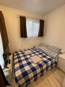 Cette petite chambre comprend un lit et une fenêtre. dans l'établissement Cottages Sosnovo Life, à Snegirëvka